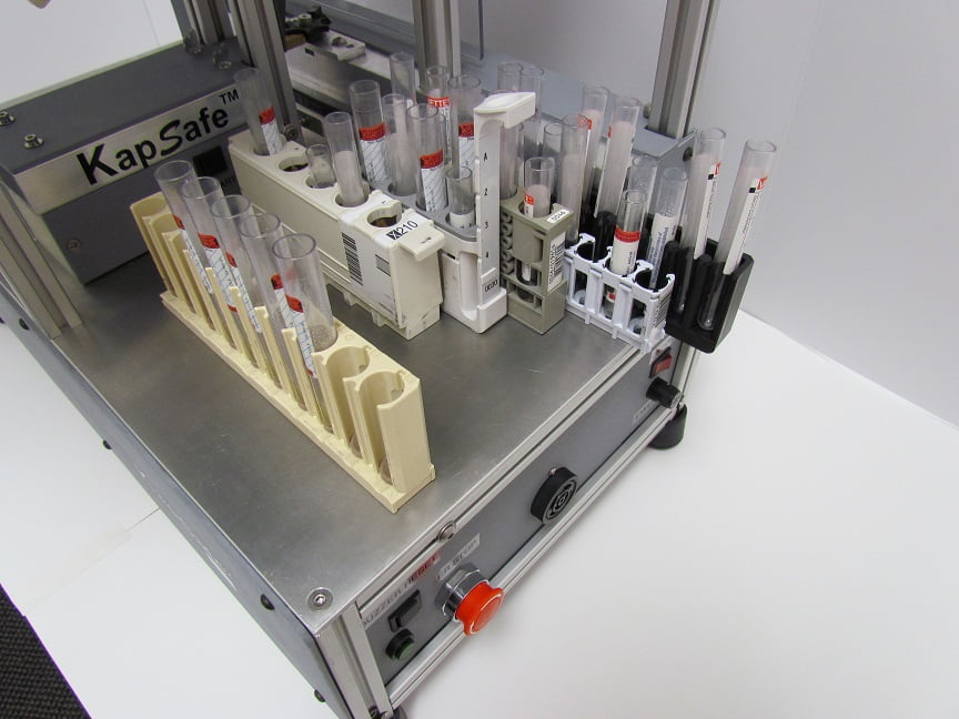 Picture of the decapper KapSafe showing different analyzer racks that can be handled by the device